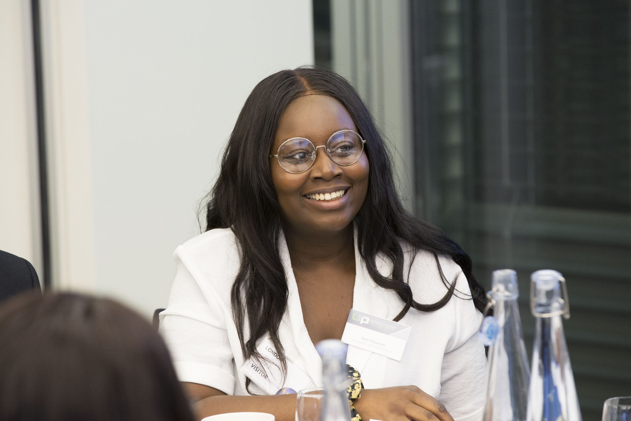 Diverse student sitting and smiling during an Uncovering Prospects event